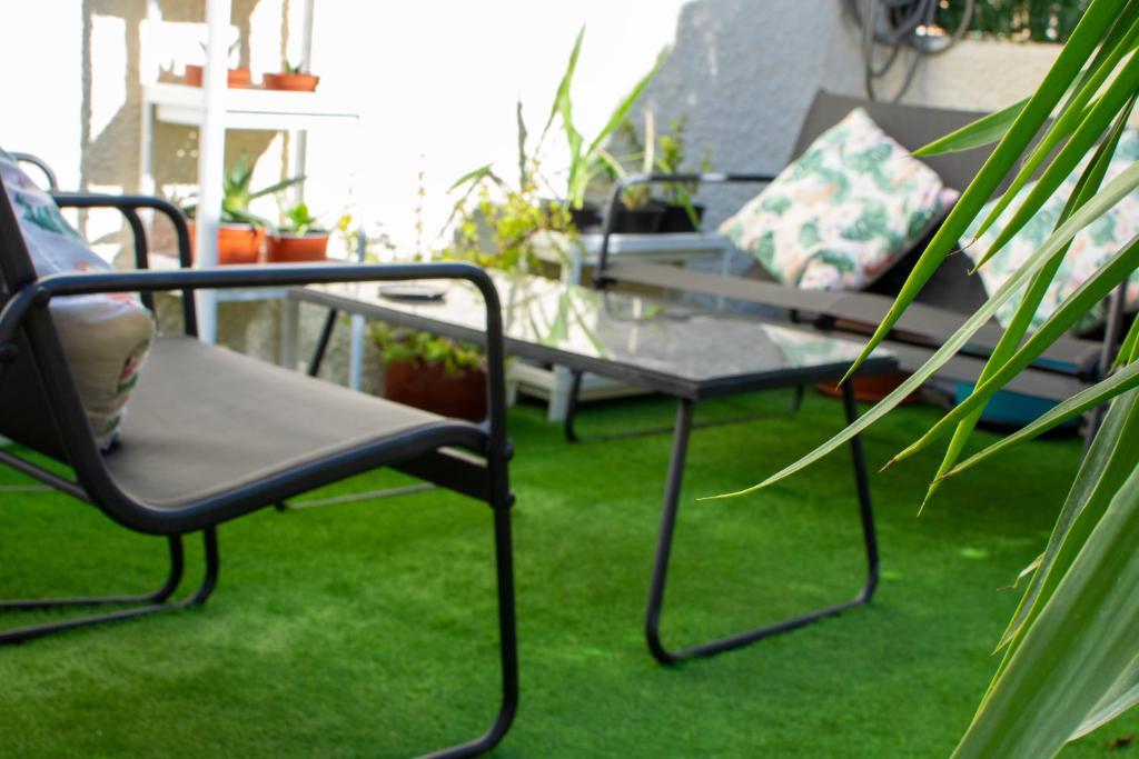een patio met 2 stoelen en een glazen tafel bij Casa Ander: Cozy and Bright Vacation Bungalow in San Fulgencio
