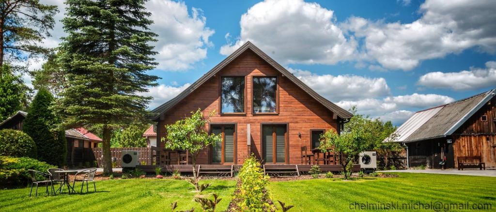 una casa de madera con un patio de césped en Dom Płociczno-Osiedle koło Suwałk, 