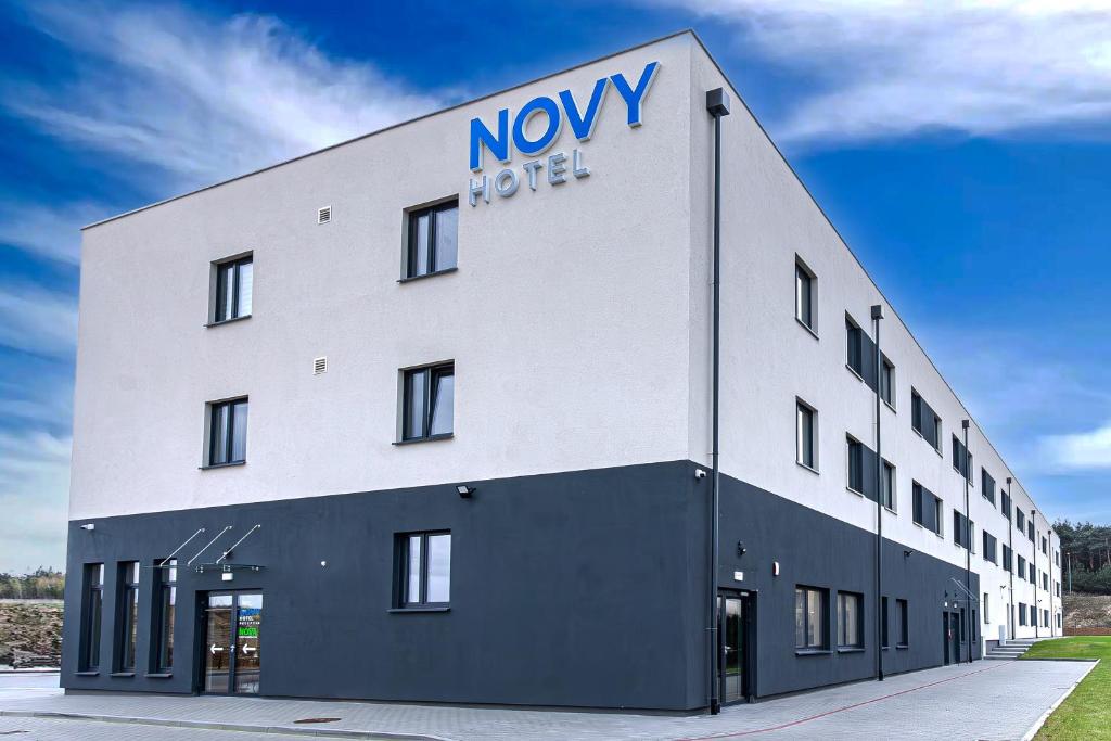 duży biały budynek z nowym znakiem hotelowym w obiekcie NOVY Hotel w Zielonej Górze