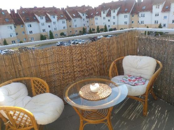 um pátio com 2 cadeiras e uma mesa e 2 cadeiras e uma mesa e cadeiras em Jasne słoneczne mieszkanie niedaleko lotniska em Gdansk