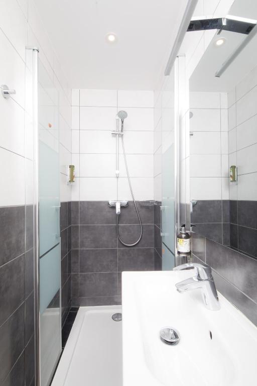 a bathroom with a shower and a white sink at Saint Aubin Logis Hôtel & Restaurant in Saint-Aubin-sur-Mer