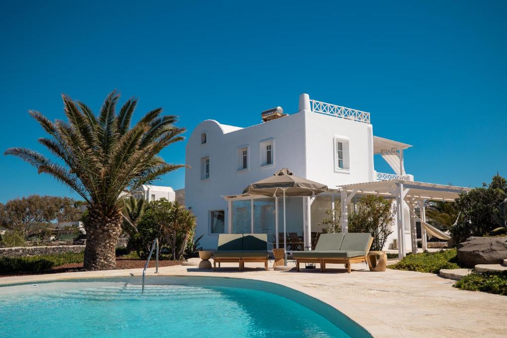 a villa with a swimming pool and a house at Oia Sunset Luxury Villa in Oia
