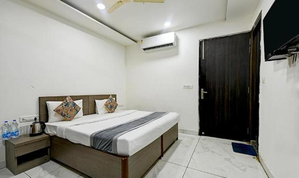 a bedroom with a bed and a black door at FabExpress The Maharaja Grand in New Delhi