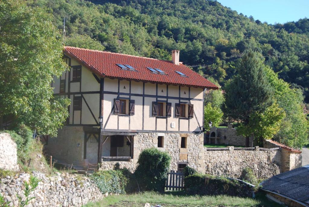 una casa con techo rojo en una montaña en Casa Rural Natura Sobron en Sobrón