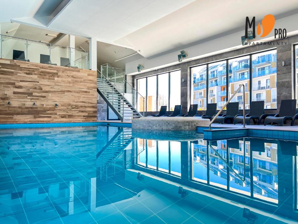 una piscina en un edificio con azulejos azules en MS Pro Apartamenty De Lux Class, en Kołobrzeg
