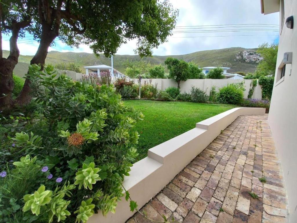 - un jardin avec une passerelle en briques dans une cour dans l'établissement Steenbok House self catering Apartment, à Hermanus