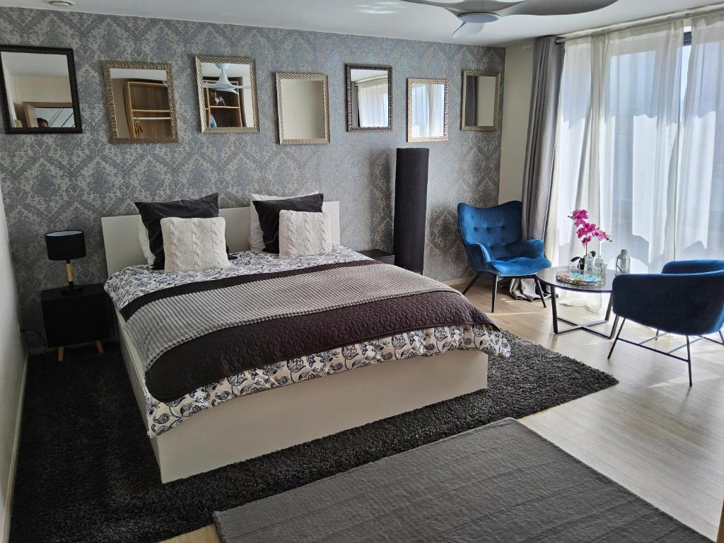 - une chambre avec un grand lit et une chaise bleue dans l'établissement Chambre deluxe au 2ème étage, chambre double au 4ème étage PAS UN HÔTEL, à Bruxelles