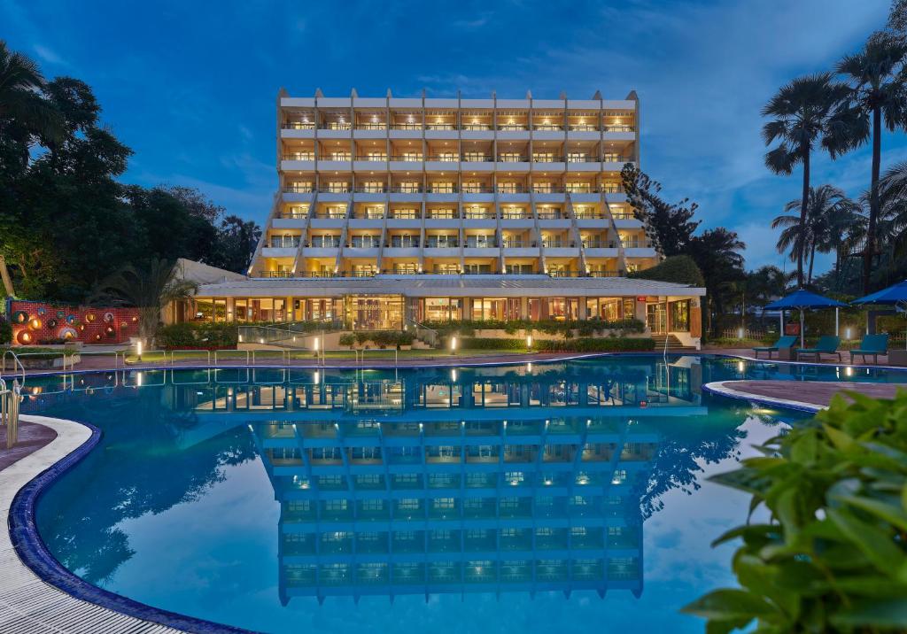 um hotel com piscina à noite em The Resort em Mumbai