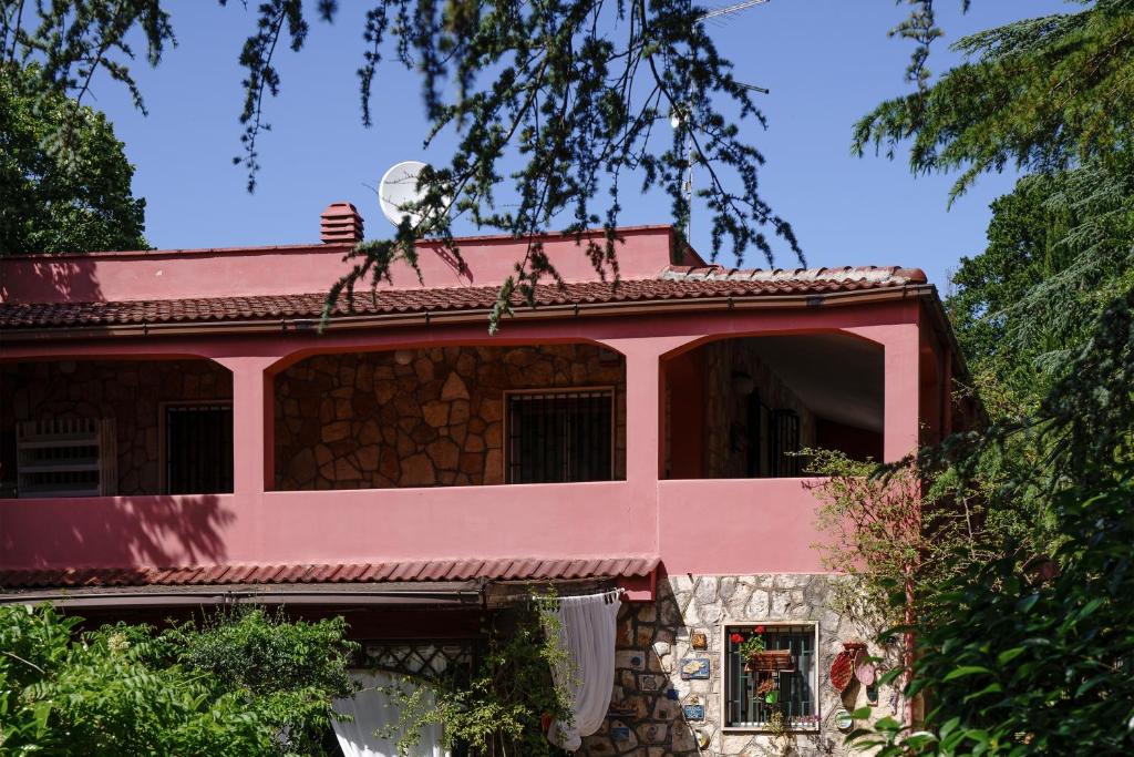 una casa rosa con un árbol en Casa Vacanze Villa Dan, en Impalata