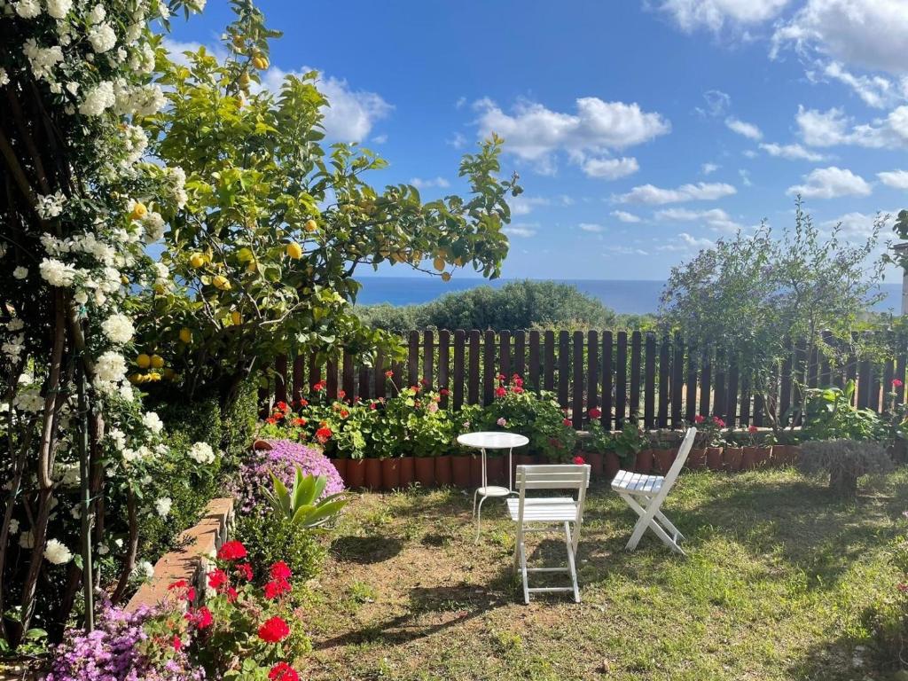 un jardín con 2 sillas, una mesa y flores en Appartamento Lavigna, en Marina di Camerota