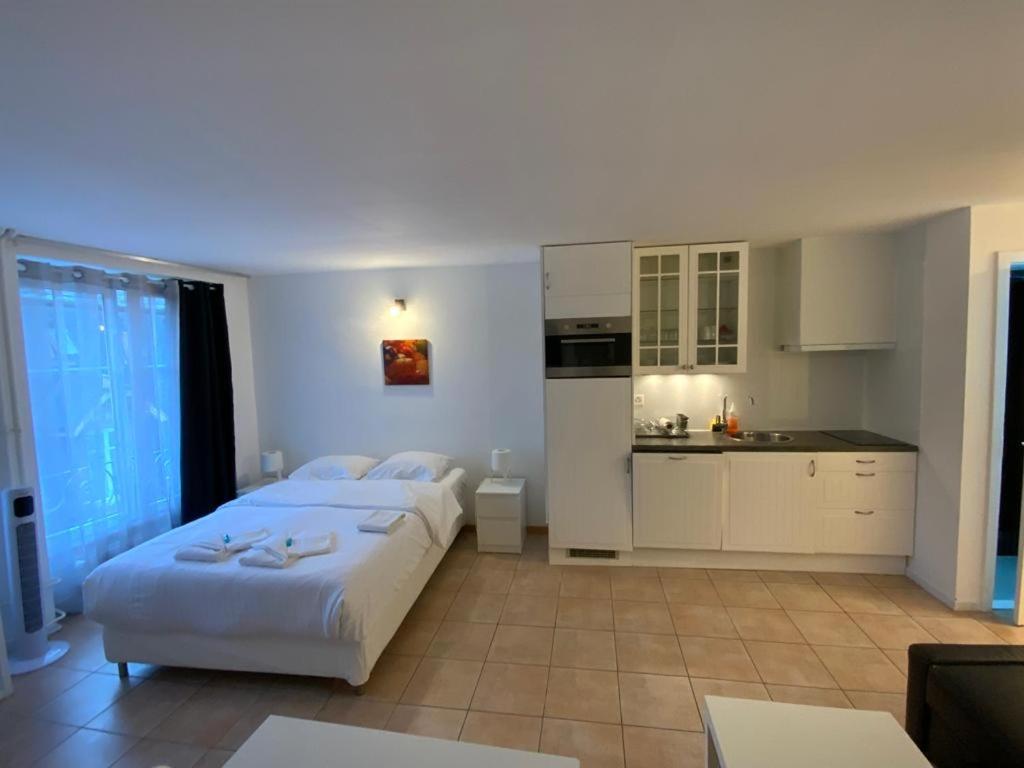 a large bedroom with two beds and a kitchen at Mango Spirit Suites in Neuchâtel