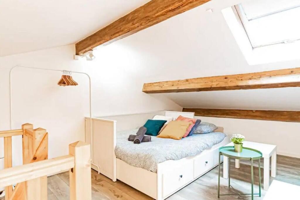 une petite chambre avec un lit et une table dans l'établissement Le Perchoir, à Villeurbanne