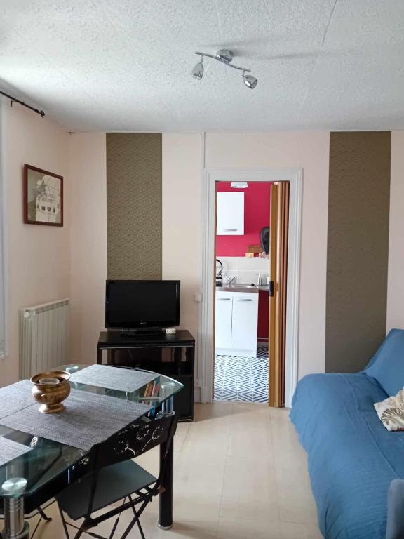 - un salon avec un canapé bleu et une table dans l'établissement Petite maison indépendante, au Havre