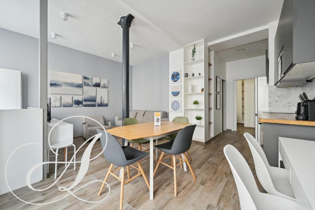 une cuisine et une salle à manger avec une table et des chaises en bois dans l'établissement Roxane, 2 chambres dont une en souplex Paris 14e, à Paris