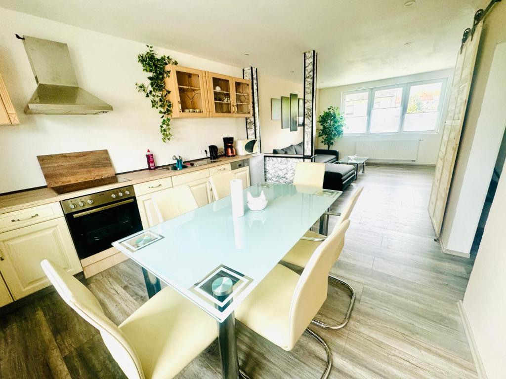 a kitchen with a glass table and chairs at Sollstedt Paradies 