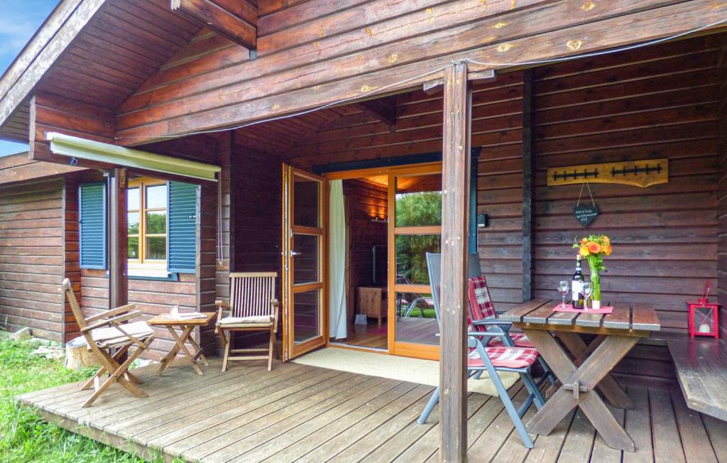 a wooden cabin with a table and chairs on a deck at Ferienhaus Donau 73 in Hayingen