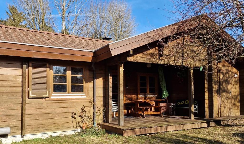 uma pequena casa com um alpendre e uma mesa em Ferienhaus Neckar 34 em Hayingen