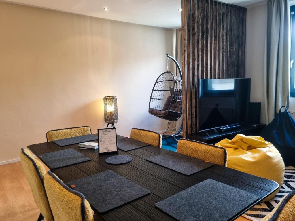 uma sala de jantar com uma mesa e uma televisão em maremar - City Design Apartment - Luxus Boxspringbetten - Highspeed WIFI - Arbeitsplätze em Braunschweig