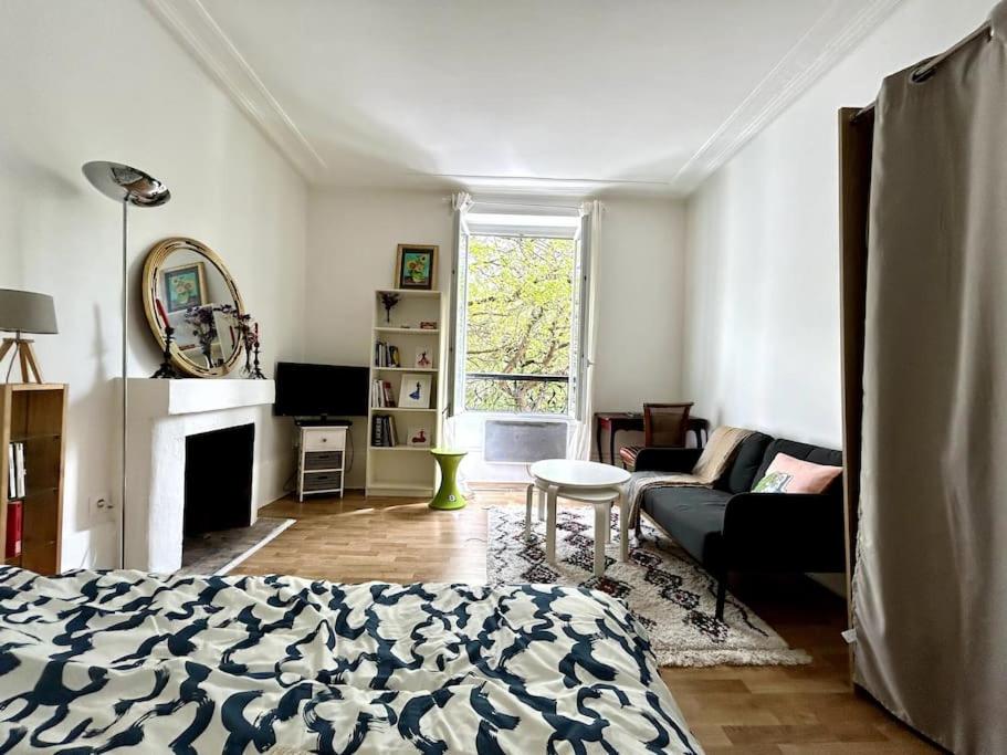 un salon avec un lit et un canapé dans l'établissement Central 1BR near Montmartre, à Paris