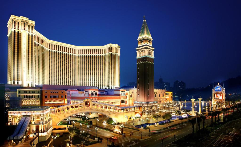 uma vista para uma cidade à noite com uma torre do relógio em The Venetian Macao em Macau