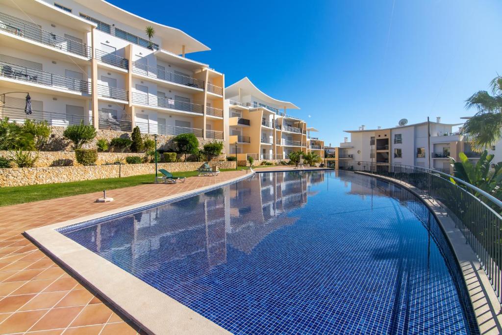 a swimming pool in front of a apartment building at by blen.d in Albufeira