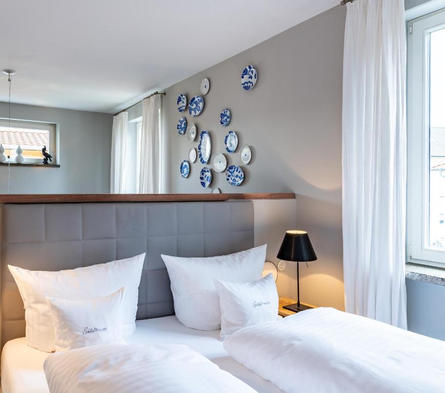 2 Betten in einem Schlafzimmer mit blauen und weißen Platten an der Wand in der Unterkunft Romantikhotel Rebstock art & design in Kehl am Rhein