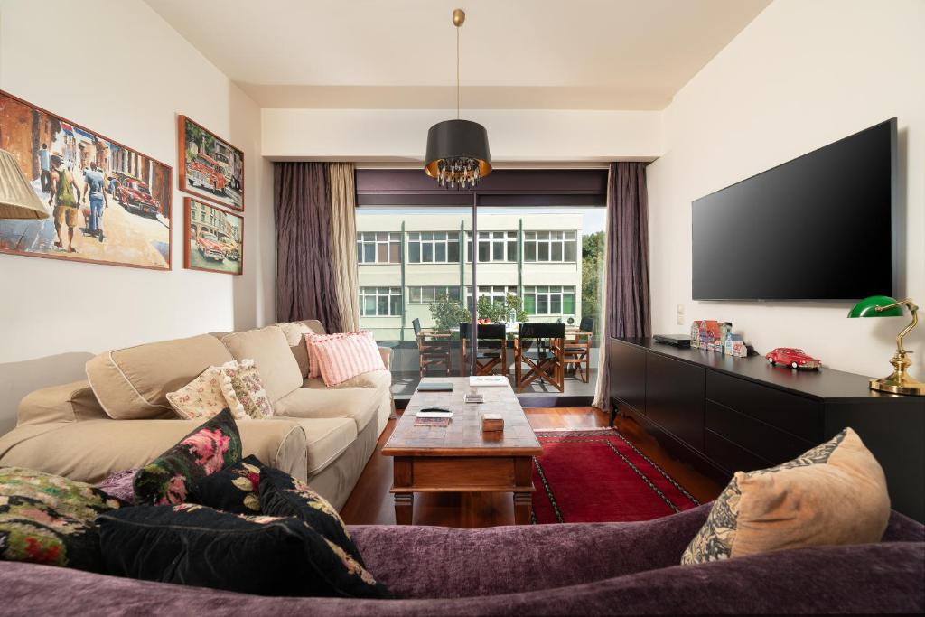 sala de estar con sofá y TV en Luxury City One-bedroom Apartment en Heraclión