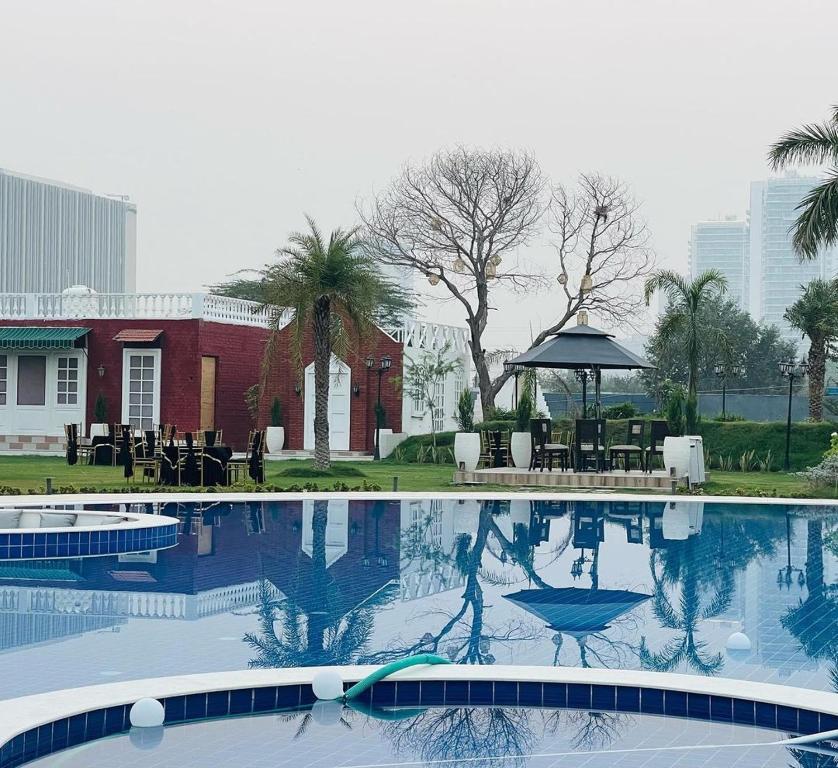 古爾岡的住宿－Tropical Palms，一个带凉亭的游泳池和一座建筑