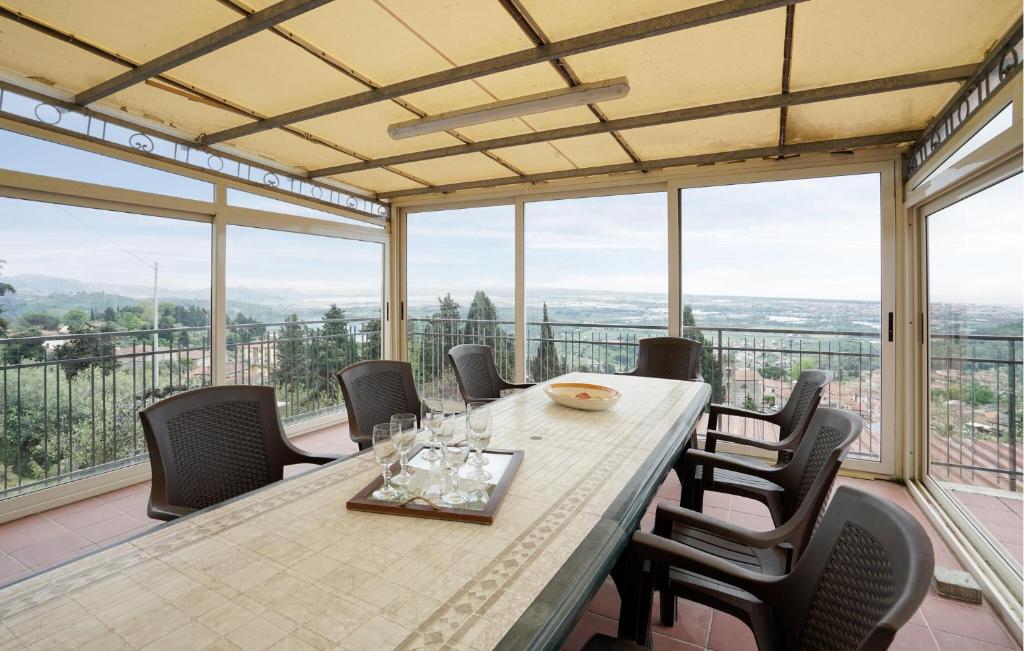 a dining room with a table and chairs and windows at Gorgeous Apartment In Corsanico With House A Panoramic View in Corsanico-Bargecchia