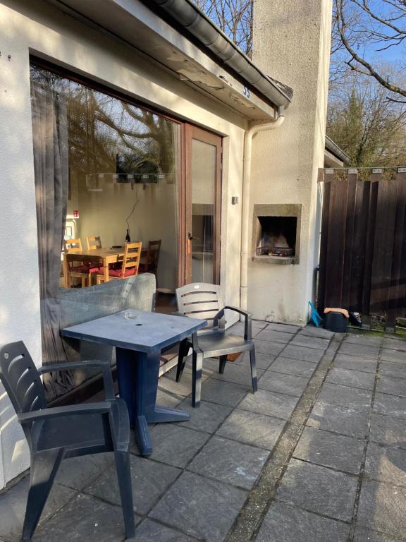een patio met een tafel en stoelen bij Mooie bungalow in de prachtige natuur in Hastière-par-delà