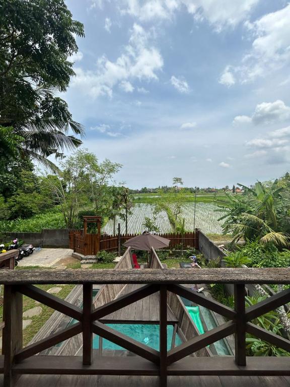- une vue depuis le pont d'une piscine et d'un champ dans l'établissement Uma Sepi Villa, à Sukawati