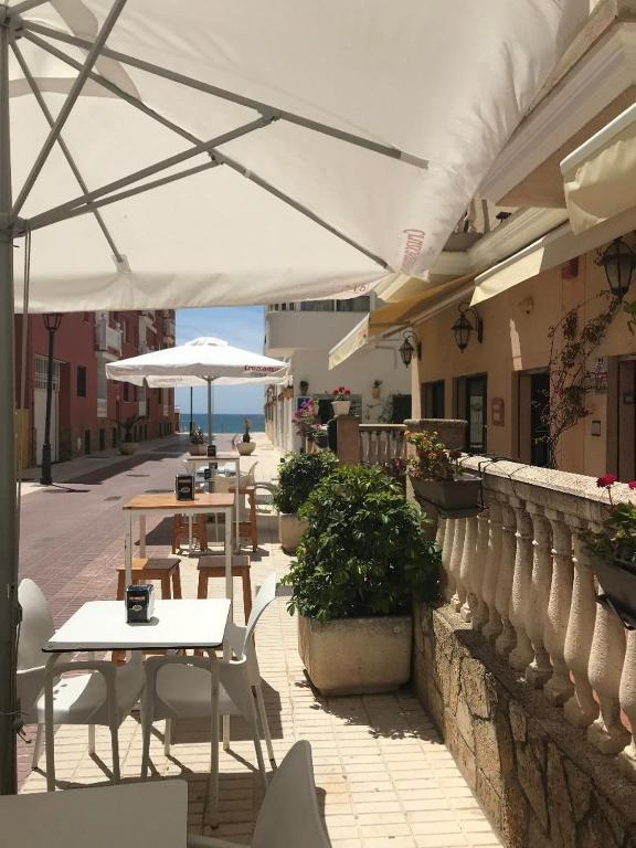 a group of tables and umbrellas on a patio at Hotel Macavi Playa in Rota
