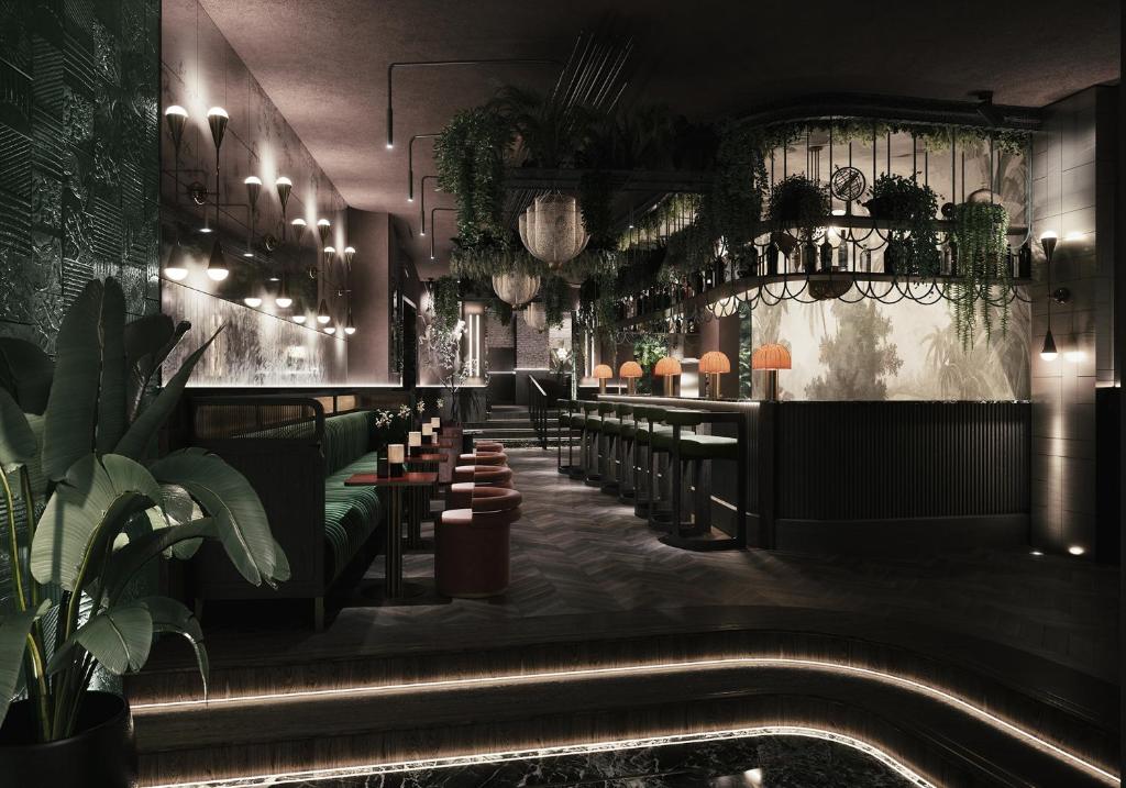 un restaurante con un bar con sillas y plantas en Gentle Hide Designhotel, en Salzburgo