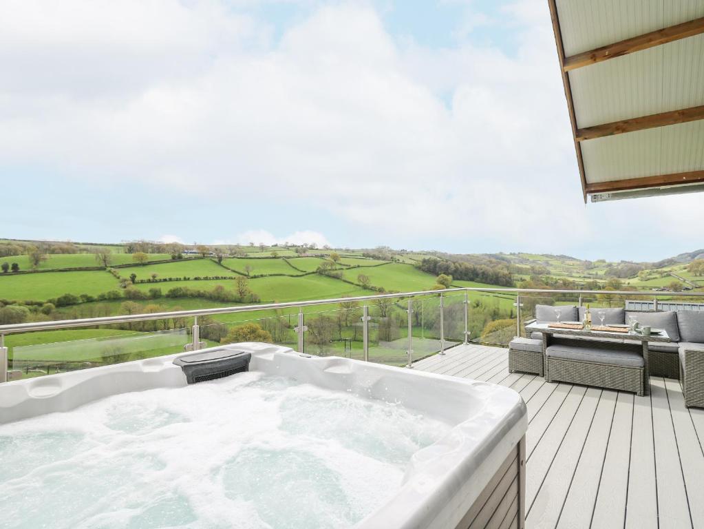 a bath tub sitting on top of a deck at Barcud Coch - Red Kite in Welshpool