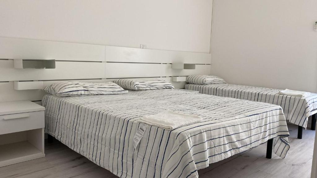 - 2 lits dans une chambre aux murs blancs dans l'établissement SoleMare, à Bellaria-Igea Marina