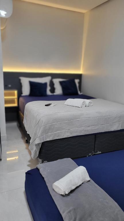 um quarto com 2 camas em azul e branco em Loft 3 Novo 5 min aeroporto Marabá em Marabá