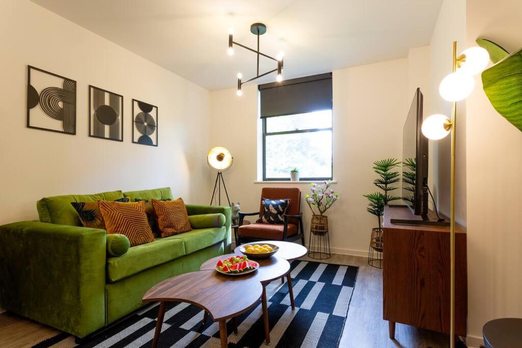 Waterside 2Bed Apartment Taunton في تونتون: غرفة معيشة مع أريكة خضراء وطاولة
