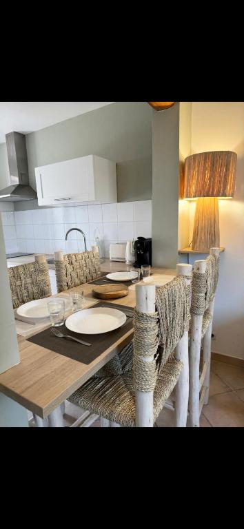eine Küche mit einem Holztisch mit Stühlen und einer Tableasteryasteryasteryastery in der Unterkunft L’oustau St Bernard in Saint-Rémy-de-Provence