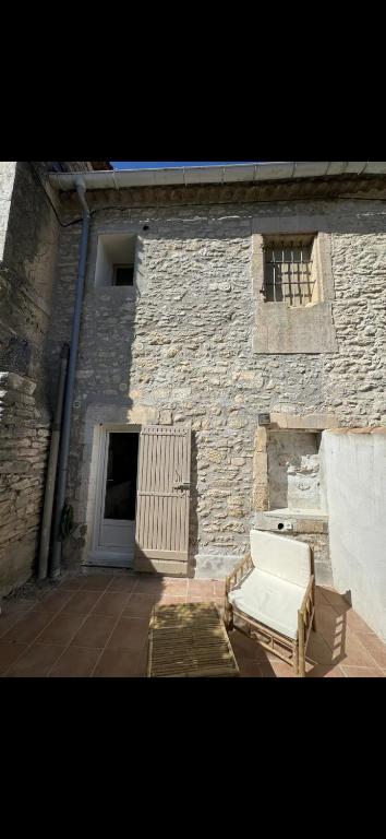 un bâtiment en briques avec un canapé blanc devant dans l'établissement L’oustau St Bernard, à Saint-Rémy-de-Provence
