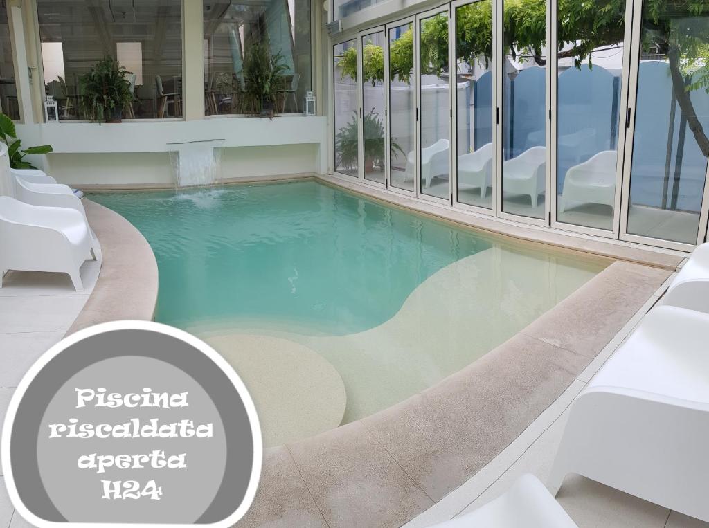 ein Schwimmbad in der Mitte eines Gebäudes in der Unterkunft Hotel Romagna in Cattolica