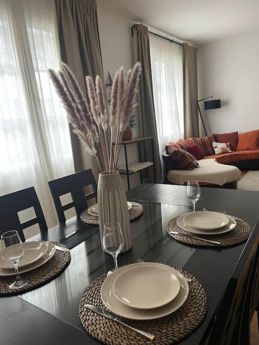 une table à manger avec des assiettes et un vase avec des fleurs dans l'établissement La Liberté-centre-ville-proche-Gare, à Rennes