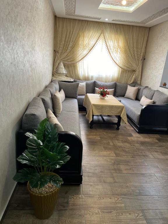 - un salon avec un canapé et une table dans l'établissement Apparemment DarBouazza AquaParc FibreWifiParkingSecurity, à Dar Bouazza
