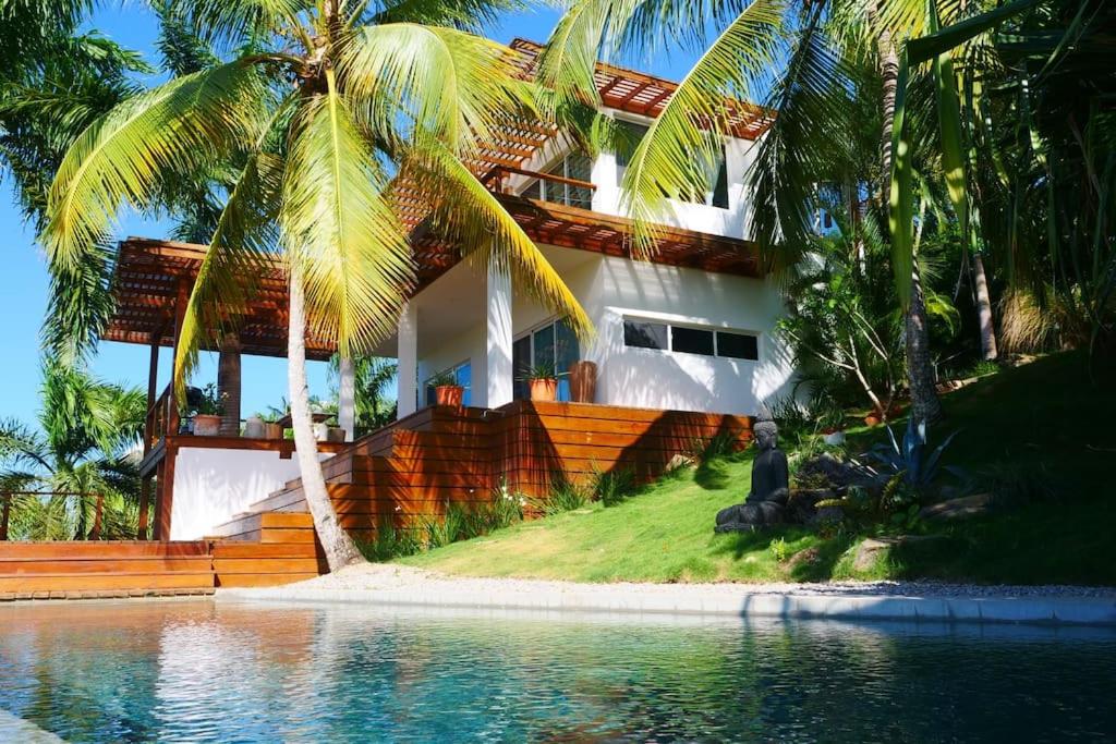 une maison avec des palmiers à côté d'une piscine dans l'établissement Villa Mata De Mango, à El Limón