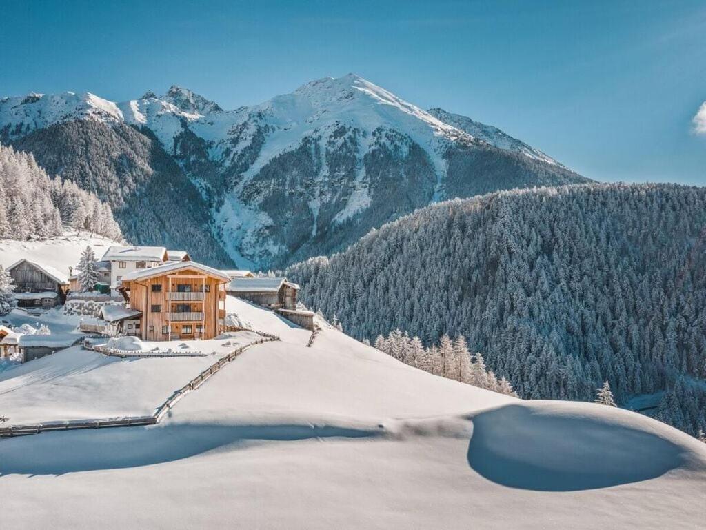 un lodge de esquí en la nieve con montañas en el fondo en Spacious holiday home near ski-lift en Umhausen