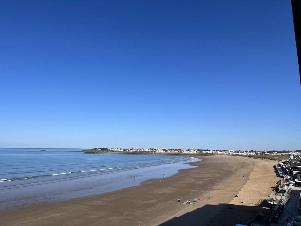 une vue sur la plage depuis le balcon d'un immeuble dans l'établissement Bel Appartement 2 Chambres avec Accès Direct Plage à Saint-Gilles-Croix-de-Vie - FR-1-324-547, à Saint-Gilles-Croix-de-Vie