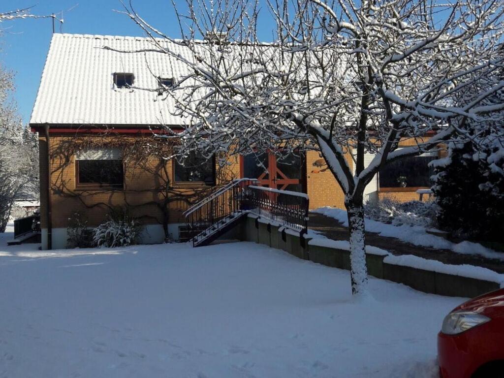 uma casa com um alpendre coberto de neve e uma árvore em Nice holiday home near town centre em Gneversdorf
