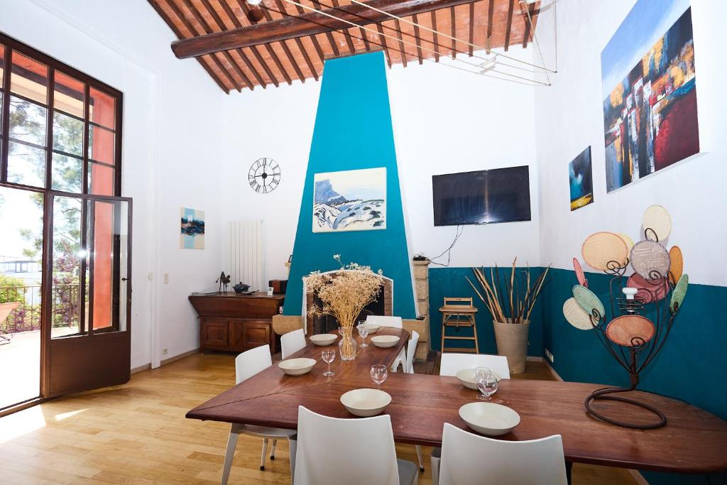 - une salle à manger avec une table et des chaises en bois dans l'établissement Appartements avec jardin dans Villa Rocaille, à Cassis