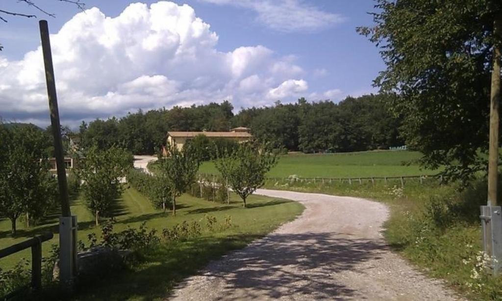 un camino de tierra que conduce a una casa en un campo en Appartement in Gavardo mit Pool, Garten und Grill, en Gavardo