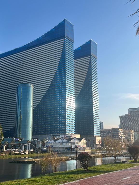 Orbi city Aparthotel في باتومي: مجموعة مباني طويلة في مدينة بها نهر