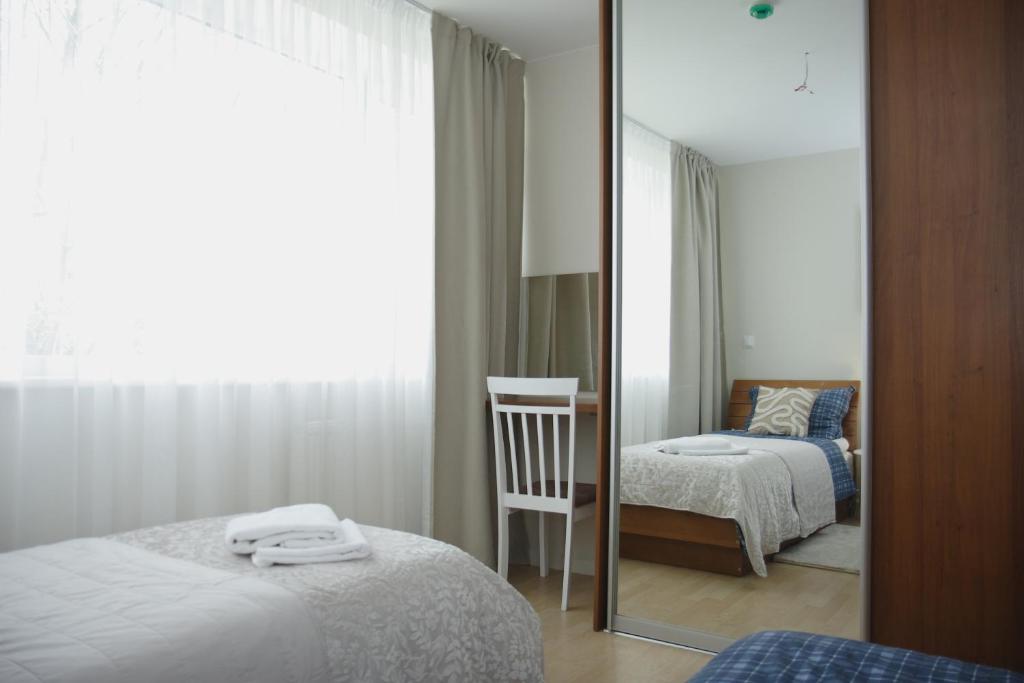 a mirror in a room with two beds and a chair at Saulene Apartments in Palanga
